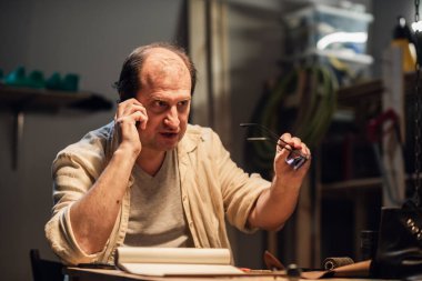 Memnun olmayan bir müşteri mağaza destek servisini arar, telefonda konuşur ve sinirlidir..