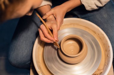 Çömlekçilik atölyesinde bir usta çömlekçi çarkında bir kap modelleme tekniğini gösterir..