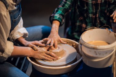 Güzel bir bayan öğretmen atölyesinde küçük bir çocuğa kilden modellik dersi veriyor..