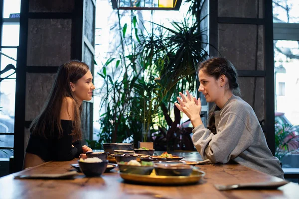 Deux copines bavardant et prenant quelques collations dans un café — Photo