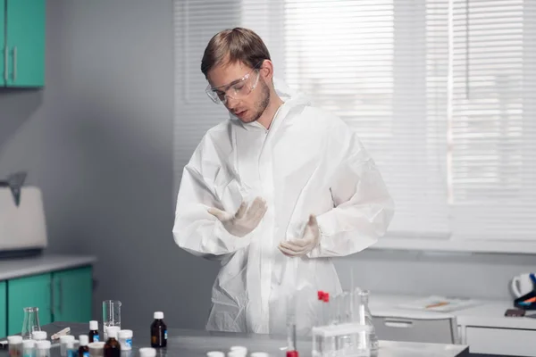 Un jeune pharmacien au travail dans une salle de laboratoire lumineuse et spacieuse — Photo