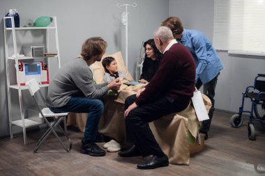 Hastane koğuşunda yatmakta olan güzel, küçük bir kızı ziyaret eden bir aile.