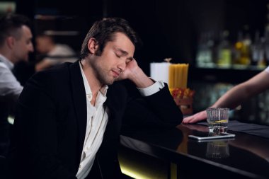 Yorgun bir adam bir restoranda barda uyuyakaldı.