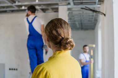 İnşaat ekibinin çalışmalarını denetleyen bir kadın.