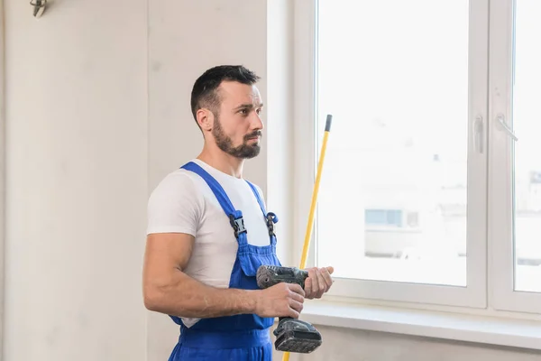 Bauarbeiter in Overalls mit Maßband in der Hand — Stockfoto