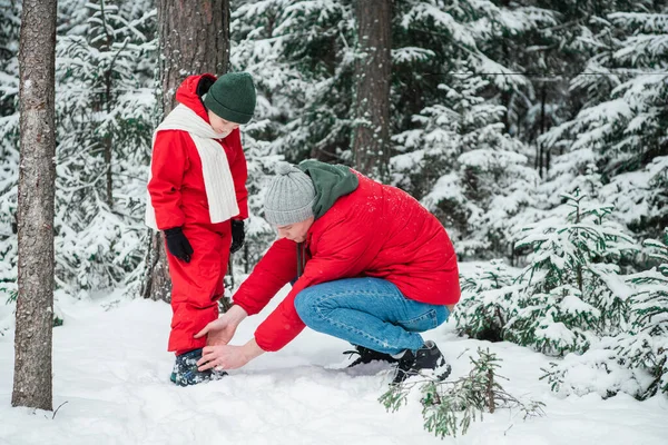 The boys shoes are unbutton oned, the man from zips up in the winter forest during a walk — стоковое фото