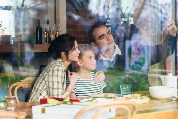 Une famille heureuse prenant un selfie à l'intérieur du café — Photo