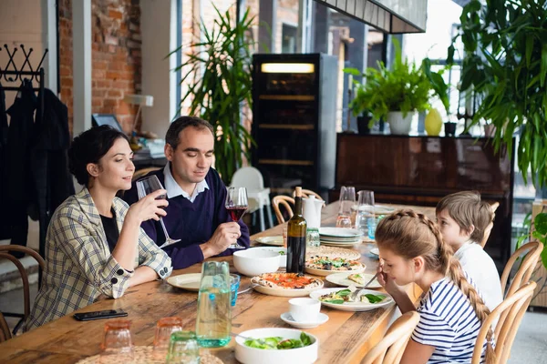 Een gezin van vier met een etentje in een café. — Stockfoto