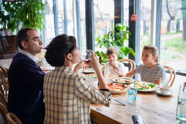 Семья из четырех человек ужинает в кафе — стоковое фото