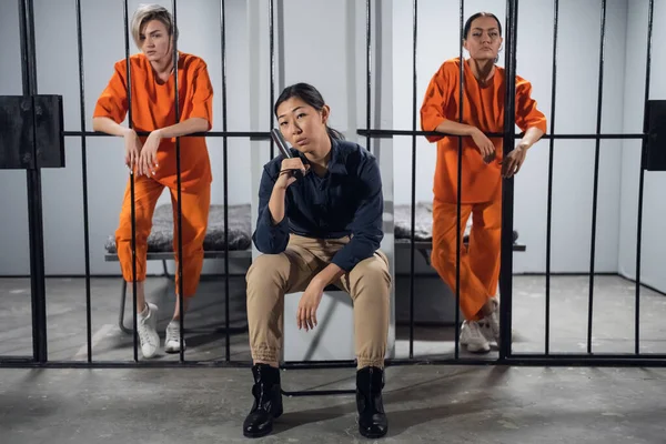 Милі молоді жінки-в'язні і їх охоронці позують для фотографії в їх клітинах — стокове фото