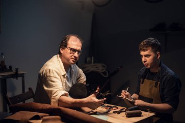 Baba-ayakkabıcı atölyesinde el yapımı ayakkabı deneyimini oğluna aktarır..