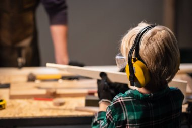 Marangozhanede işçi öğretmeni olan küçük bir çocuk..