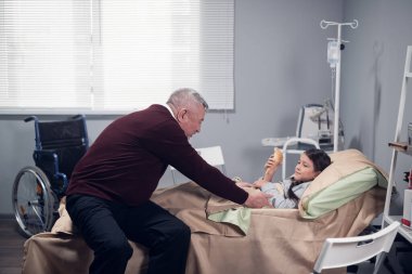 Son sınıf öğrencisi, hastane koğuşunda yatmakta olan torununu neşelendirirken ona dondurma getirmiş.