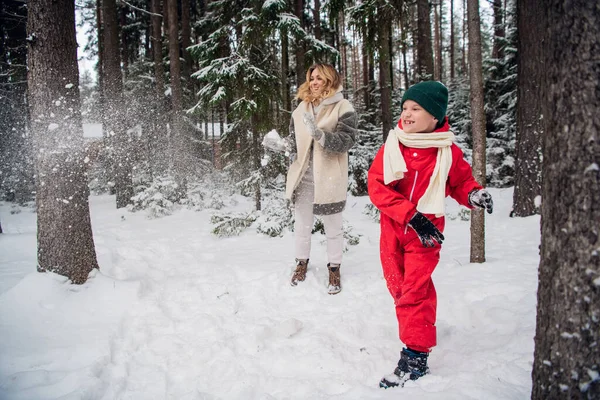 Divertidos jogos de família ao ar livre em uma manhã fria de inverno, mãe e filho brincam na floresta — Fotografia de Stock