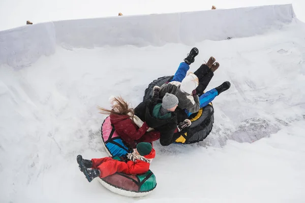 Entretenimento de inverno para toda a família passeio de montanha-russa, mãe, pai, filha, filho estão felizes e gostam de passar tempo juntos — Fotografia de Stock