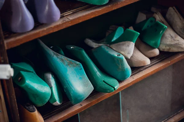 En el taller en un estante de madera se colorean espacios en blanco para diferentes zapatos —  Fotos de Stock