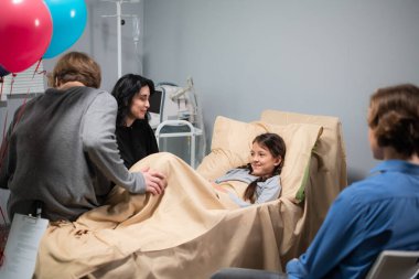 Kazadan sonra güzel, küçük bir kızı ziyarete gelen bir aile. Kız hastanede yatıyor.