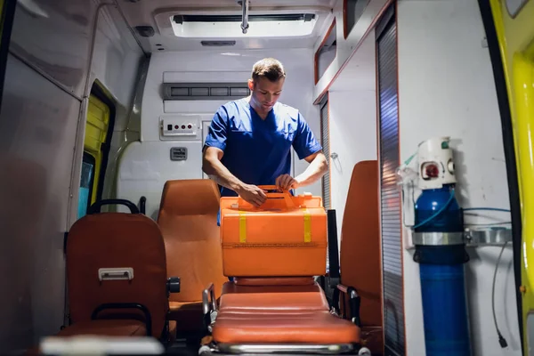 Молодой врач готовит аптечку в машине скорой помощи — стоковое фото