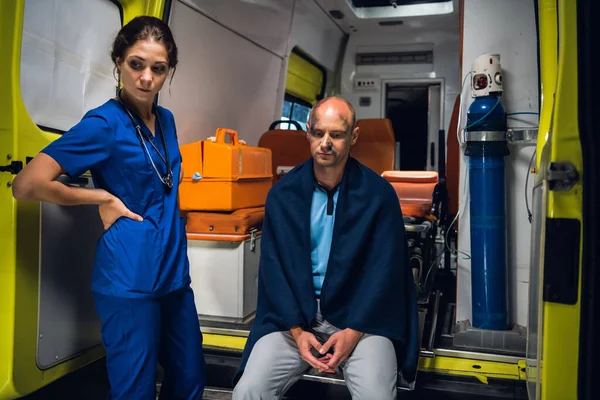Un paramédico y un paciente en un coche ambulancia — Foto de Stock