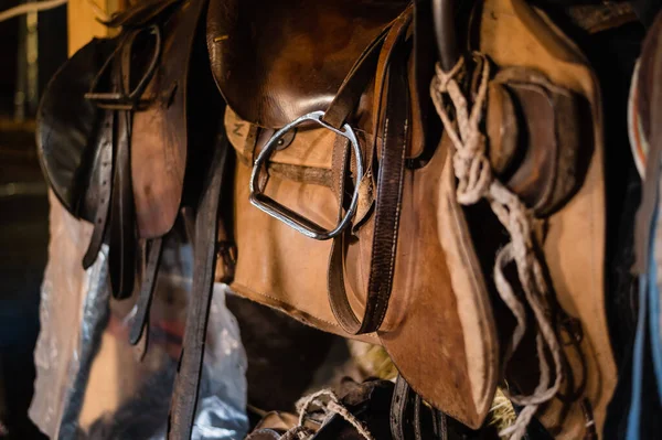 Um conjunto de equipamentos de equitação em um estábulo de madeira no clube equestre — Fotografia de Stock