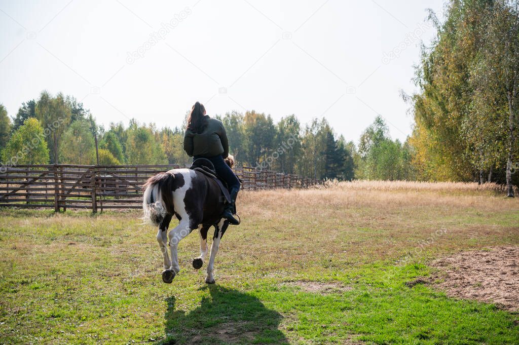 Horse ride of a young girl in places with beautiful autumn countryside landscapes