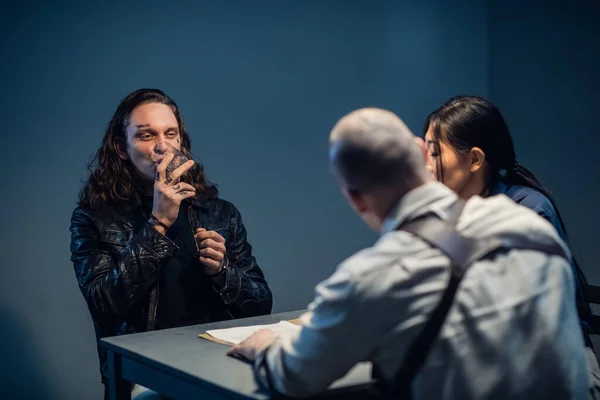 Досвідчені кримінальні сміхи перед обличчям слідчих під час допиту — стокове фото