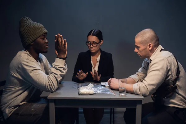 Una guapa abogada está presente en el interrogatorio de un criminal negro detenido con drogas en la calle — Foto de Stock