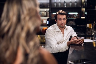 Beyaz gömlekli bir adam gece kulübünde genç bir kızla tanışıyor ve onunla flört ediyor.