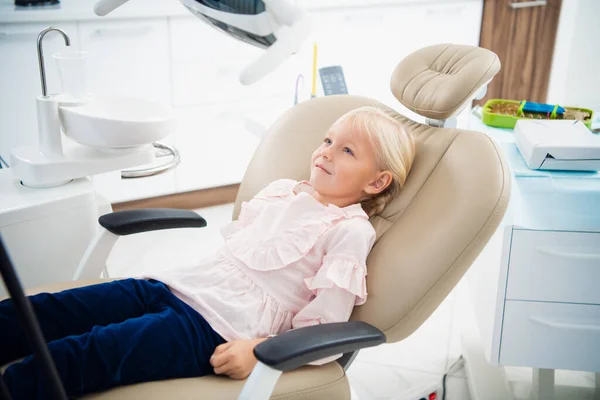 Κοντινό πλάνο ενός μικρού κοριτσιού που περιμένει στο οδοντιατρείο για να ελέγξει τα δόντια της. — Φωτογραφία Αρχείου