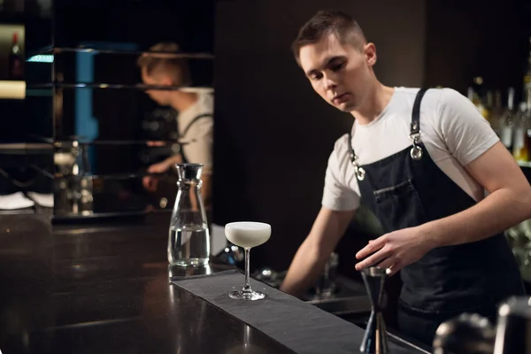Молодий бармен приготував молочний коктейль і поклав його на бар — стокове фото