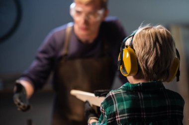 Küçük bir çocuk, bir marangoz dükkanında tüfeğin ahşap bir modelini yaptı ve onunla oynadı..