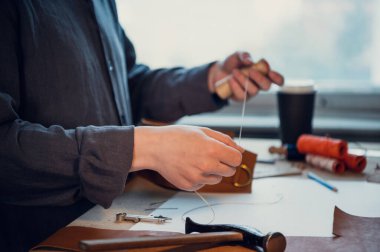 Tecrübeli bir ayakkabıcı ya da terzi geniş, parlak bir stüdyoda eşsiz bir deri diker.