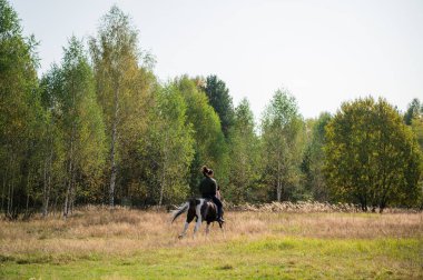 Sıcak bir sonbahar gününde, genç bir kız atıyla çiftliğin etrafında dolaşmaya çıktı.