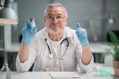 Ofisteki deneyimli bir tıp uzmanı hastalarına cam ampuldeki en son koronavirüs aşısını öneriyor.