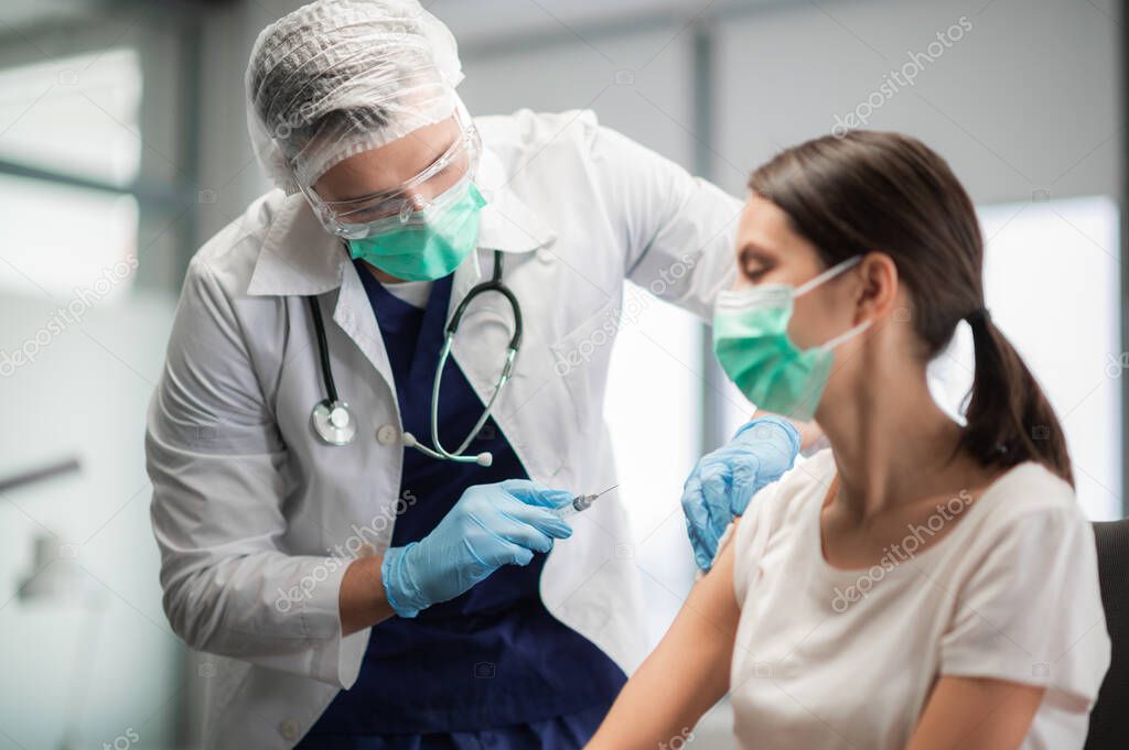 The covid-19 vaccine is injected into a young womans hand