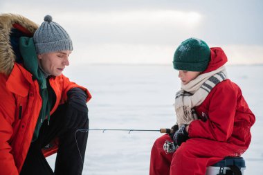 Tecrübeli bir balıkçı baba, küçük oğluna kışın balık avlamak için teçhizat kullanmayı öğretir..