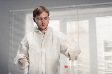 Genç bilim adamı analizciyi laboratuvarda numunelerle doldurmaya hazırlanıyor.