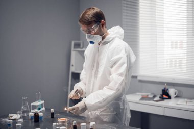 Kimya laboratuvarı iş başında. Bir bilim araştırmacısı test ettiği materyali ateşe veriyor.