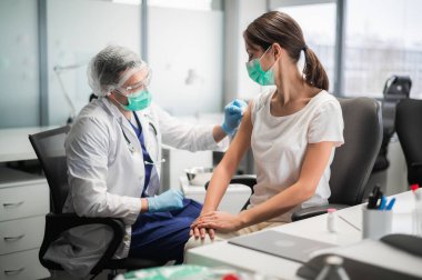 Covid-19 aşısı genç bir kadının eline enjekte edildi.