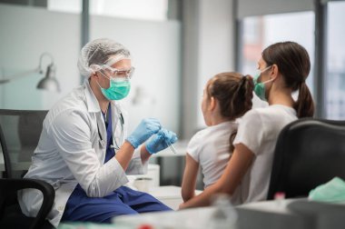 Salgın sırasında, aile covid-19 testi yaptırır, laboratuvar asistanı kızdan örnek alır.