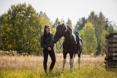 Sonbaharda çiftlikte at taşıyan bir kızı gezdiriyorum.