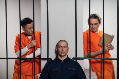 Beyaz ve Asyalı tehlikeli suçlular ve seri katiller hücrelerini koruyan silahlı muhafızlara saldırıyor. Parmaklıklardan geçerek ellerini güvenlik görevlisine uzatıyor..