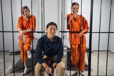 Şirin genç kadın mahkumlar ve gardiyanları hücrelerinde fotoğraf çektirmek için poz veriyorlar.