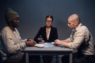 Bilinmeyen beyaz madde içeren bir paketle gözaltına alınan bir uyuşturucu satıcısı, deneyimli bir müfettiş tarafından bir avukatın huzurunda sorgulanır.