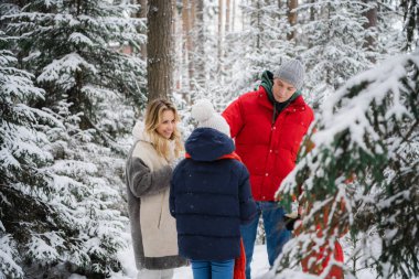 İki çocuklu mutlu bir aile kış ormanında dışarıda vakit geçirir. Termos ve kupalardan sıcak çay içerler..