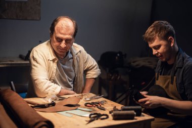 Baba-ayakkabıcı atölyesinde el yapımı ayakkabı deneyimini oğluna aktarır..