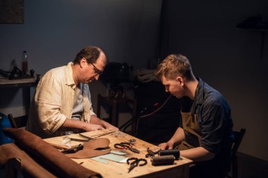 Baba-ayakkabıcı atölyesinde el yapımı ayakkabı deneyimini oğluna aktarır..