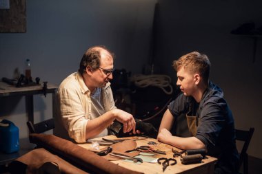 Deneyimli bir ayakkabıcı ve asistanı atölyelerinde deriden siparişe ayakkabı yapıyorlar..