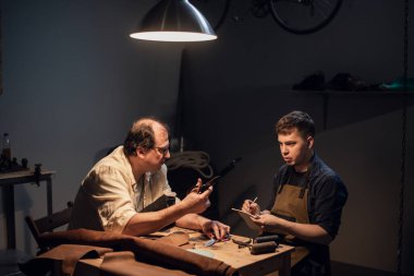 Deneyimli bir ayakkabıcı ve asistanı atölyelerinde deriden siparişe ayakkabı yapıyorlar..