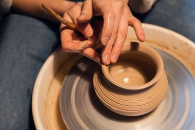Çanak çömlek okulunda ders, bir kap yontma, yakın plan.